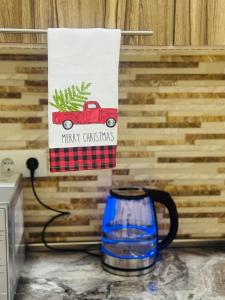 Une pancarte « Joyeux Noël » et une tasse en forme de camion rouge sur un comptoir dans l'établissement NOYemi, à Goris 2 autres photos