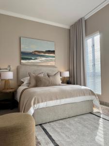 a bedroom with a large bed and a window at Palm Springs in Struisbaai