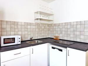 een keuken met een spoelbak en een magnetron bij Zentrales 2-SZ-Apartment Nr 6 - Top-Lage am HBF in Krefeld