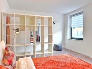 een slaapkamer met witte muren en een grote boekenkast bij Zentrales 2-SZ-Apartment Nr 6 - Top-Lage am HBF in Krefeld