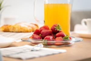 un piatto di fragole su un tavolo con una bevanda di Colosseum Holidays - Marco Aurelio a Roma