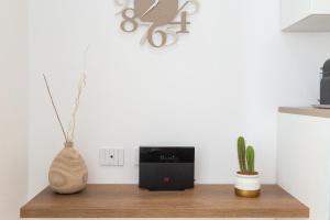 soggiorno con tavolo, altoparlante e cactus di Colosseum Holidays - Marco Aurelio a Roma Altre 48 foto