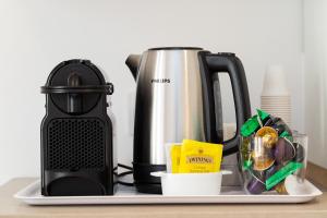 una macchina per il caffè su un bancone con un bollitore per il tè di Colosseum Holidays - Marco Aurelio a Roma