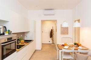 una cucina e una sala da pranzo con tavolo e sedie di Colosseum Holidays - Marco Aurelio a Roma