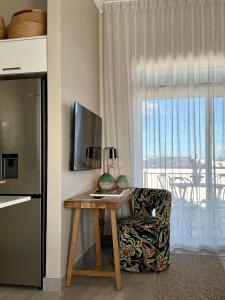 a room with a table and a chair and a window at Palm Springs in Struisbaai
