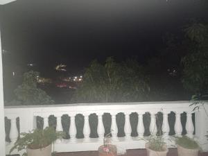 a white fence with potted plants on a balcony at night at Come Chill on the Hill in Nazareth