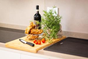 una bottiglia di vino e un tagliere con pane e pomodori di Colosseum Holidays - Marco Aurelio a Roma