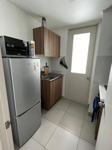 eine Küche mit Edelstahlkühlschrank und Fenster in der Unterkunft Dep al costado del hospital- cercano a safari - buena accesibilidad a carretera panamericana 5 - parking privado in Rancagua