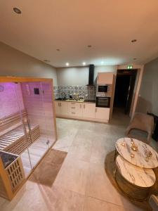 ein Wohnzimmer mit Tisch und Küche in der Unterkunft La nuit de rêve Suite privative Jaccuzi Sauna Suite 2 in Crouy