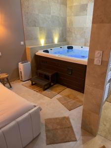 ein Bad mit einer großen Badewanne in einem Zimmer in der Unterkunft La nuit de rêve Suite privative Jaccuzi Sauna Suite 2 in Crouy