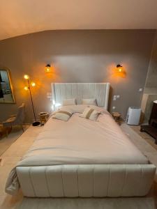 ein großes weißes Bett in einem Schlafzimmer mit zwei Lichtern in der Unterkunft La nuit de rêve Suite privative Jaccuzi Sauna Suite 2 in Crouy