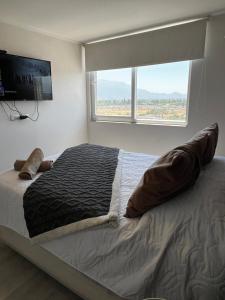ein Schlafzimmer mit einem großen Bett mit einem großen Fenster in der Unterkunft Dep al costado del hospital- cercano a safari - buena accesibilidad a carretera panamericana 5 - parking privado in Rancagua