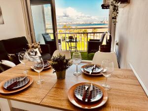 a wooden table with plates and wine glasses on it at Paradis Costa in La Pineda