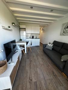 a living room with a couch and a television at Paradis Costa in La Pineda