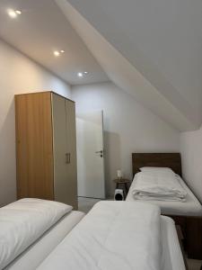 a bedroom with two beds and a cabinet at KARTAL centar apartment in Bihać