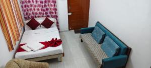 a bedroom with a bed and a couch and a chair at Omkar Bungalow in Alibaug