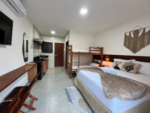 a hotel room with two beds and a desk and a sink at Toca do Lobo in Pipa