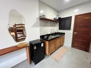 a kitchen with a sink and a mirror on the wall at Toca do Lobo in Pipa