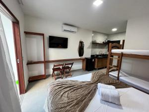 a room with a bedroom with a bed and a kitchen at Toca do Lobo in Pipa +16 photos