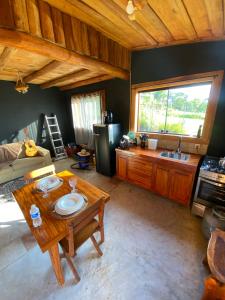 a living room with a table and a kitchen at Cabana Rústica em Piedade in Piedade