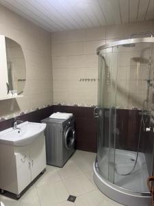 une salle de bain avec douche et machine à laver dans l'établissement NOYemi, à Goris