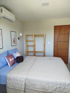 a bedroom with a large white bed and a door at 05 minutos da praia - Casa Superior céu azul Buzios in Búzios