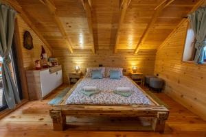 ein Schlafzimmer mit einem großen Bett in einem Holzzimmer in der Unterkunft Family Oasis, Plaški in Plaški