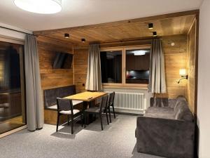 een eetkamer met een tafel, stoelen en een bank bij Alpenresort Panorama in Oberperfuss