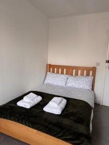 a bedroom with a bed with two towels on it at NextDoor Morden in Merton