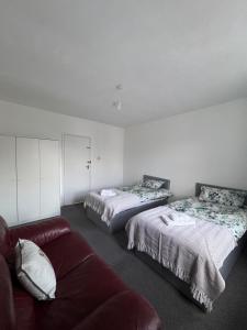 a living room with two beds and a couch at NextDoor Morden in Merton