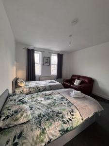 a hotel room with two beds and a couch at NextDoor Morden in Merton +18 photos