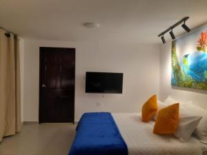 una camera da letto con un letto e una TV a parete di Finca El Rosal a Alcalá