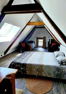 ein Schlafzimmer mit einem großen Bett im Dachgeschoss in der Unterkunft Gîte CosyCool in Languidic
