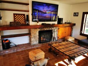 a living room with a table and a fireplace at Villa Can Raurell Casa rural para 14 en Girona in Sant Feliu de Buixalleu