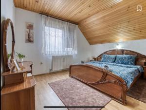 a bedroom with a large bed and a wooden ceiling at Kuća za odmor Maklen in Brod Moravice +39 photos