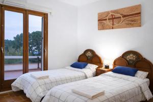 two beds in a room with a balcony at Villa Can Raurell Casa rural para 14 en Girona in Sant Feliu de Buixalleu +19 photos