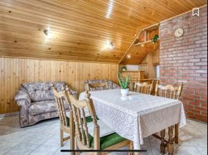 a dining room with a table and a couch at Holiday Home Maklen Gorski kotar with sauna and jacuzzi in Brod Moravice