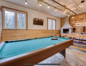 a pool table in a room with a fireplace at Kuća za odmor Maklen in Brod Moravice