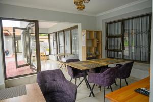 ein Esszimmer mit einem Holztisch und lila Stühlen in der Unterkunft 5@Partridge Guesthouse in Newcastle