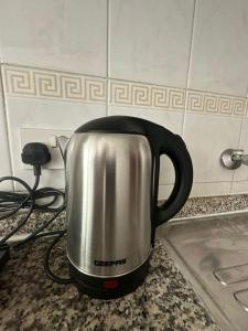 a silver and black kettle sitting on a counter at Abu Dhabi City Private Room Late Check out 2pm in Abu Dhabi