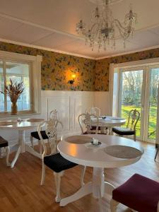 a dining room with tables and chairs and a chandelier at Vrensted Hostel B&B in Løkken