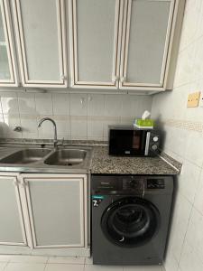 une cuisine avec une machine à laver et un évier dans l'établissement Downtown Private room, à Abu Dhabi 26 autres photos