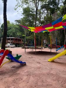 een speeltuin met kleurrijke speeltoestellen in een park bij Cabanas Carijó in Santarém