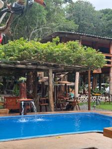 a swimming pool with a fountain in front of a house at Cabanas Carijó in Santarém