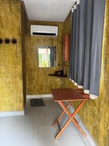 een kamer met een houten tafel en een gordijn bij Cabanas Carijó in Santarém