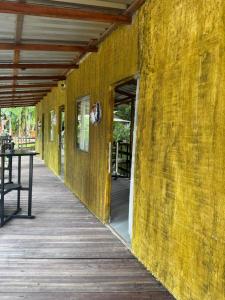 een gebouw met een gele muur en een houten loopbrug bij Cabanas Carijó in Santarém +1 foto