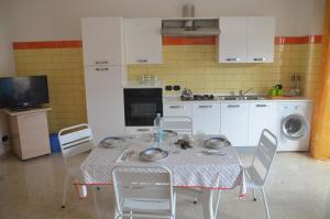 a kitchen with a table and chairs and a sink at Taormina Bay Lucia's House Roccalumera in Roccalumera