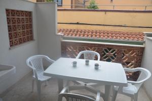 a white table and chairs on a balcony with a piano at Taormina Bay Lucia's House Roccalumera in Roccalumera