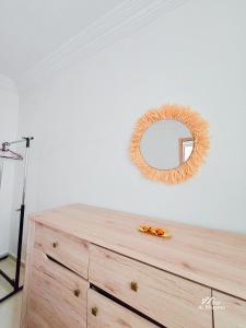 eine Kommode mit einem Spiegel darüber in der Unterkunft Entire condo hosted by Dar Al Khayma in Agadir