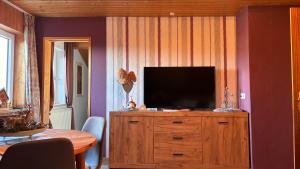 een woonkamer met een televisie op een houten dressoir bij Ferienwohnung Raith in Regen